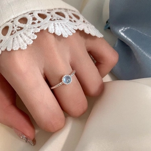 Gros plan sur une bague torsadée en argent S925 avec un cristal rond bleu clair et pur