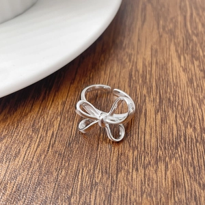 Detail shot of a 925 sterling silver bow ring with S925 hallmark on a wooden surface