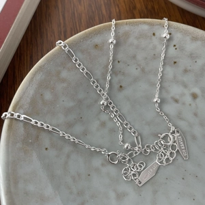 Detailed close-up of S925 sterling silver chain with tiny beads and engraved logo tag