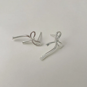 Gros plan détaillé de boucles d'oreilles nœuds en argent poli au fini métallique