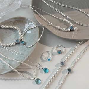 Macro shot of S925 silver pearl necklaces and bracelets with blue gemstone details