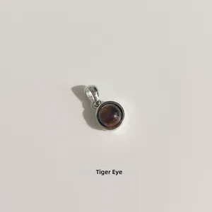 Détail macro d'un pendentif en oeil de tigre avec serti clos en argent brillant