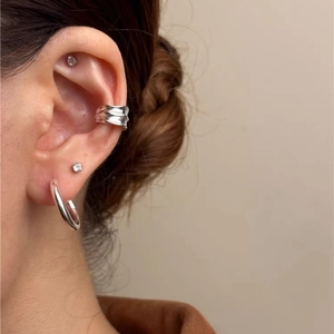 Irregular textured silver ear cuff and hoop earring set styled on a female model