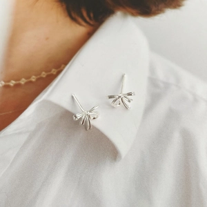 Boucles d'oreilles nœud en argent sur un col de chemise blanche style élégant
