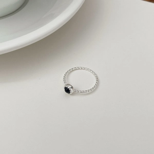Détail d'une bague en argent 925 avec anneau torsadé et pierre d'onyx noire ronde