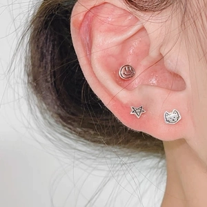 Vue macro d'un ensemble de boucles d'oreilles S925 argent avec smile, étoile et chat