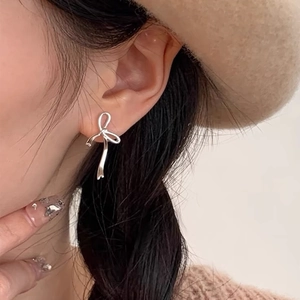 Boucles d'oreilles nœud en argent sterling S925 portées par un mannequin élégant