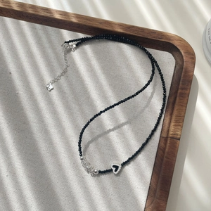 Vue détaillée du collier en perles de spinelle noire avec pendentif cœur et chaîne argent