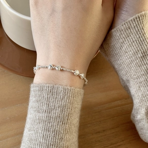 Bracelet perles en argent sterling S925 avec breloques cœur sur poignet féminin