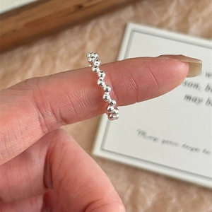 Detail of S925 sterling silver beaded ring on finger with natural ambient lighting