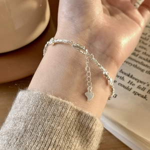Gros plan détaillé d'un bracelet en argent avec pendentif cœur et fermoir mousqueton
