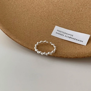 Detailed view of S925 sterling silver hollow geometric ring on cork and white surface
