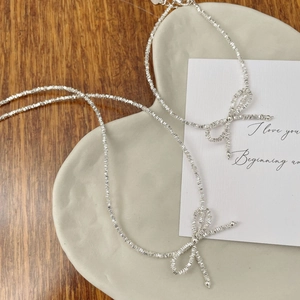 Minimalist S925 sterling silver bowknot bracelet with crushed silver beads on ceramic tray