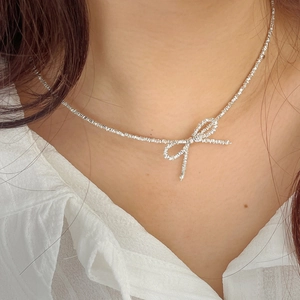 Macro shot of a silver S925 butterfly bow necklace on collarbone with delicate details
