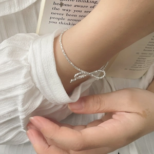 Macro detail of S925 silver bow bracelet with textured crushed silver finish