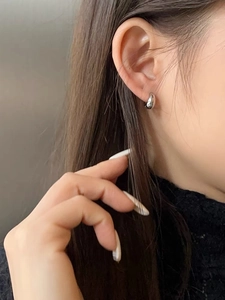 Close-up of minimalist 925 silver droplet hoop earrings on a female model