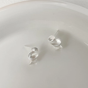 Vista macro dettagliata degli orecchini in argento 925 con design a onde opache