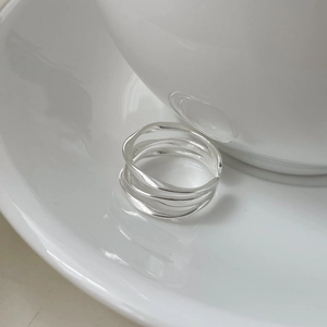 Détail macro d'une bague en argent S925 ajourée à trois couches de fils entrelacés