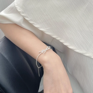 Close-up of S925 sterling silver bow bracelet with adjustable chain on a model's wrist
