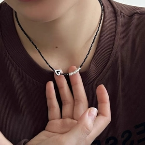 Collier en argent S925 avec perles noires et pendentif cœur sur le cou du mannequin