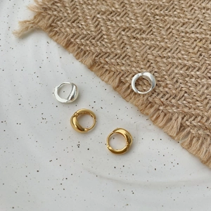 Detail of S925 sterling silver stamp on minimalist gold and silver hoop earrings