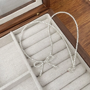Detailed close-up of a S925 sterling silver bow bracelet with textured crushed silver beads