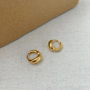 Detailed close-up of S925 sterling silver stamp on minimalist gold huggie hoop earrings