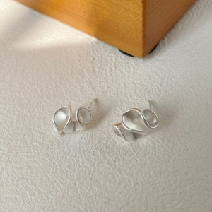 Macro di orecchini a lobo minimalisti a onda in argento S925 con finitura satinata opaca