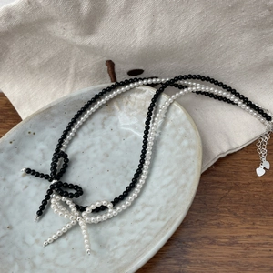 Elegant S925 sterling silver bow necklace with black and white beads in a layered style