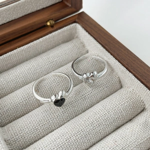 Gros plan de bagues coeur en argent S925 avec pierres noires et claires dans un coffret