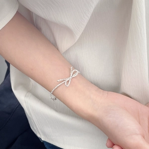 Detailed view of S925 sterling silver bow bracelet with sparkling textured crushed silver finish