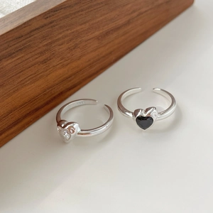 Détail de bagues ajustables en argent S925 avec zircons blancs et noirs en forme de cœur