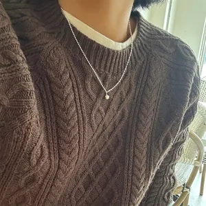 Collier minimaliste en argent S925 avec pendentif perle sur un pull marron