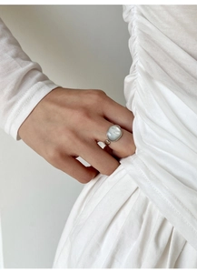 Gros plan d'une bague en argent S925 avec une grande pierre ovale en nacre et perle