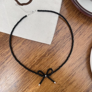 Detail of S925 sterling silver bow pendant necklace with black beaded chain and clasp
