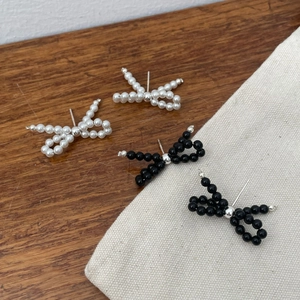 Handcrafted bow-shaped pearl stud earrings in elegant black and white bead designs