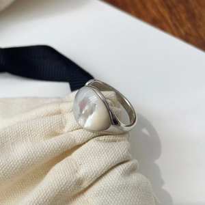 Bague ouverte minimaliste en argent S925 avec pierre de nacre ovale sur lin texturé
