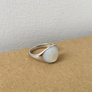 Gros plan détaillé sur la grande pierre de nacre ovale de la bague en argent réglable