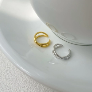 Close-up of S925 hallmark on minimalist X-shaped crossover ear cuff set in gold and silver