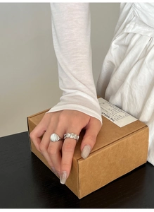 Détail de bagues en argent S925 avec pierre de coquillage ovale et zircon sur une main