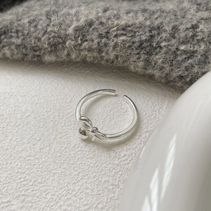 Vista macro dell'anello a fiocco in argento S925 con marchio inciso e finitura lucida