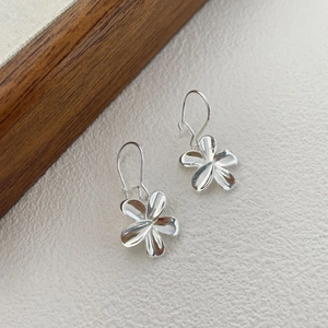 Detailed close-up of S925 silver five-petal flower earrings with polished metallic finish
