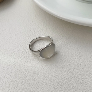 Détail d'une bague ovale S925 en argent avec pierre de nacre sur surface texturée