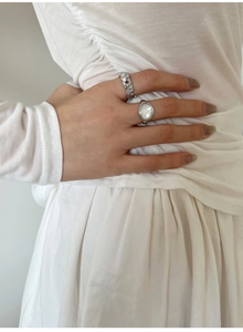 Détail du lot de bagues géométriques en argent avec nacre et texture sur main