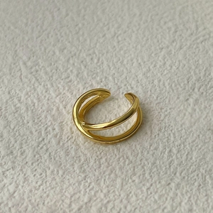 Detailed close-up of a polished gold X-shaped criss-cross ear cuff with a smooth finish