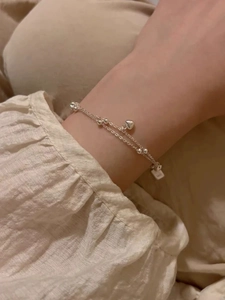 Détail du bracelet double couche en argent S925 avec cœurs et perles porté au poignet