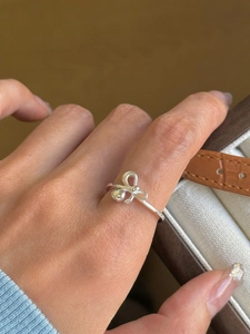 Primo piano dell'anello a fiocco minimalista in argento lucido per donna elegante