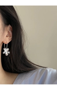 Macro shot of S925 silver flower earrings with textured liquid metal petals on a model