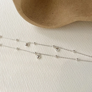 Vue détaillée du bracelet double couche en argent S925 avec pendentifs en cœur