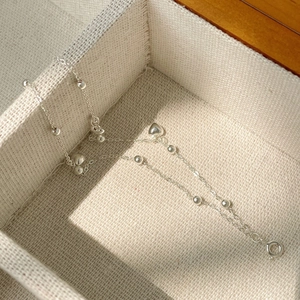 Gros plan d'un bracelet double couche en argent avec cœurs et perles métalliques